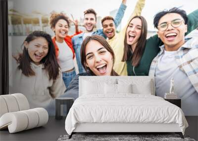 Multiracial friends taking selfie group picture with smart mobile phone outside on city street - Happy young people smiling together looking at camera - Youth lifestyle concept with teens hanging out Wall mural