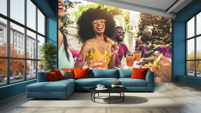 Multiracial group of friends having fun at backyard home party - Young people laughing together drinking cocktails at bar restaurant - Focus on black woman Wall mural