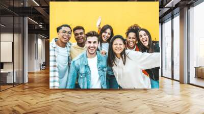 Multiracial group of young people standing in front of yellow isolated background - Youth community concept with guys and girls laughing looking at camera - Bright colors Wall mural