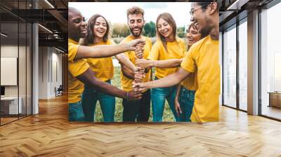 Multiracial happy young people stacking hands outside - University students hugging in college campus - Youth community concept with guys and girls standing together supporting each other Wall mural