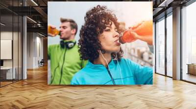 Sporty runners couple drinking energy drink  Wall mural