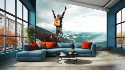 Successful hiker man jumping on the top of the mountain - Successful, business and sport concept. Wall mural