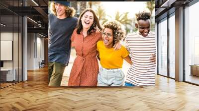 Young happy people laughing together - Multiracial friends group having fun on city street - Diverse culture students portrait celebrating outside - Friendship, community, youth, university concept.	
 Wall mural