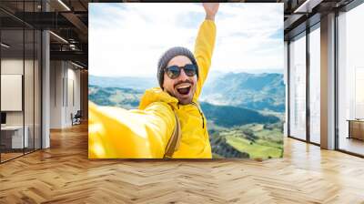 Young hiker man taking selfie portrait on the top of mountain - Happy guy smiling at camera - Hiking, sport, travel and technology concept - Bright filter Wall mural