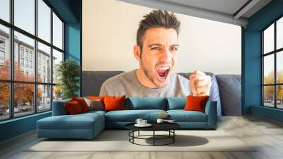 Young man with a joystick for game console Wall mural