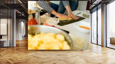 hands of young woman making venezuelan christmas dish hallacas with all ingredients on table Wall mural