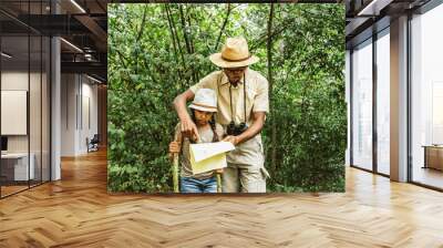 Father and daughter's green adventure, learning the art of orientation surrounded by lush foliage. A summer adventure filled with learning and discovery. Wall mural