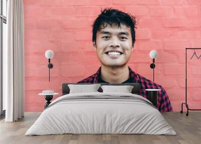 Happy Asian guy portrait - Confident asian young male having fun smiling while posing in front of camera against a red wall background Wall mural