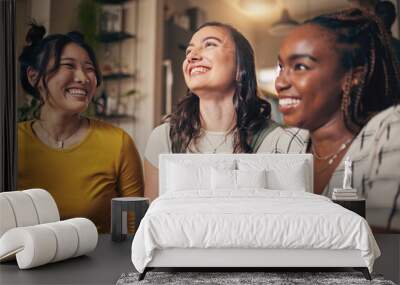 Happy, friends and women in a living room with funny, conversation and bond in their home together. Gossip, smile and people with diversity in a house for reunion, weekend and relax on day off Wall mural