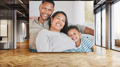 Mom, dad and kid in portrait on sofa for bonding, love and relax together in home on weekend morning. Mother, father and boy child hug on couch with smile, happy family and embrace in living room Wall mural