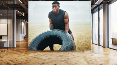 Nature, fitness and man with tire for workout with strength, muscles and body building training. Sports, fog and African male athlete with equipment for arm exercise with weight challenge in field. Wall mural