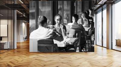 A young couple drinking wine in a restaurant near the window. Wall mural