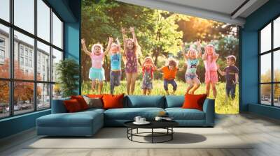 Group of friends running happily together in the grass and jumping. Wall mural