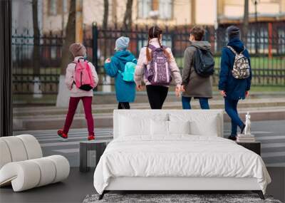 School children cross the road in medical masks. Children go to school. Wall mural