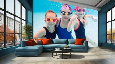 Underwater photo of young friends in swimming pool. Wall mural