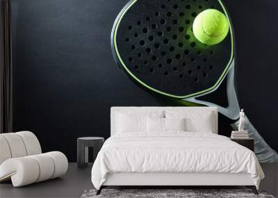 black padel racket and two balls on a black table Wall mural