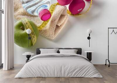 Dumbbells with apple bottle and tape measure and towel elevated Wall mural