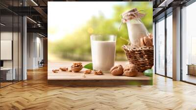 Glass of alternative vegetable drink of walnuts in a field Wall mural