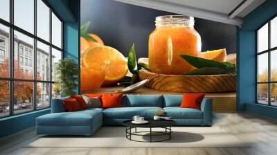 Jar of orange jam on bench and dark background Wall mural