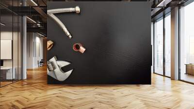 Plumbing conceptual background with wrench and pipes on black table Wall mural