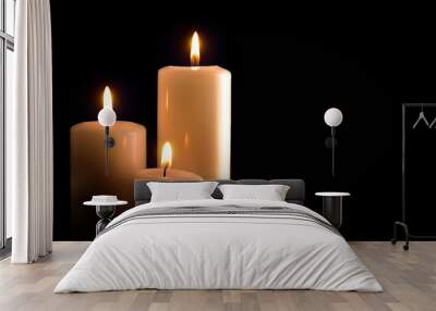 Three burning candles isolated black front view Wall mural