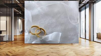 Two gold rings tied with ribbon on white cloth top Wall mural