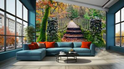 Two stone pillars and steps of old wooden bridge with mossy rocks in Tollymore Forest Park in autumn, Newcastle, County Down, Northern Ireland Wall mural