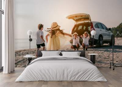 Asian family vacation holiday, Happy family running on the beach in the sunset..Children are running to their parents behind cars.Holiday and travel family concept, Summer vacations. Wall mural