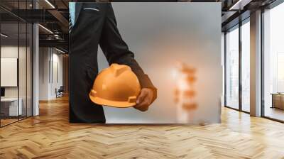 Close-up the male engineer is carrying a safety hat thinking of ways and ideas for building new buildings in the future. Engineering concepts and architecture Wall mural