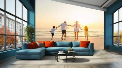 Family, travel, beach, relax, lifestyle, holiday concept. Family who enjoy a picnic. Parents are holding hands their children and walking on the beach at sunset in holiday. Wall mural