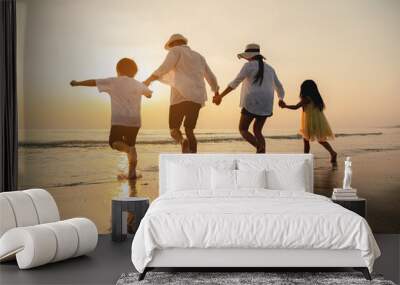 Happy asian family at consisting father, mother,son and daughter having fun playing beach in summer vacation on the beach.Happy family and vacations concept. Wall mural