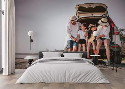 Happy family enjoying beach trip with their favorite car. Wall mural