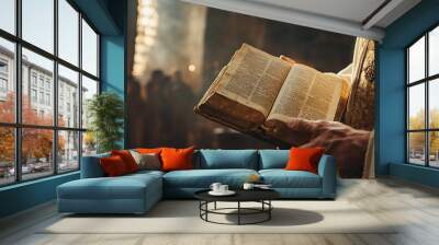 A figure holds an open book in a dimly lit, atmospheric setting. Wall mural