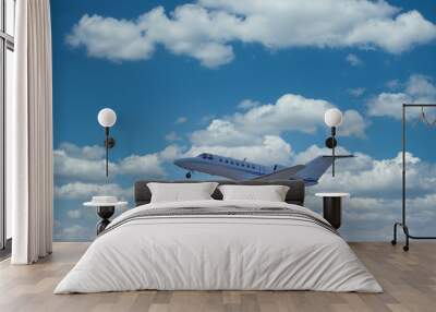 A small private jet ascending through the sky and clouds Wall mural