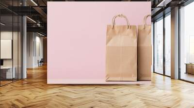 Two brown paper bags on a light pink background, showcasing simplicity and eco-friendliness in packaging. Wall mural