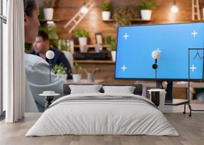 Businesswoman sitting at desk looking at mock up green screen chroma key computer with isolated display analyzing marketing project ideas. Manager woman working at company strategy in startup office Wall mural