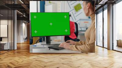 Company worker using isolated green screen on monitor with chroma key. Business woman looking at computer with mock up template and background in startup office. Mock-up copy space Wall mural