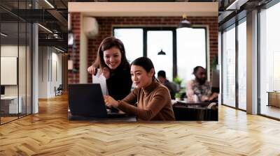 Company worker working with female wheelchair user in office, doing teamwork to plan strategy. Woman with chronic disability and health condition analyzing project report, talking to colleague. Wall mural