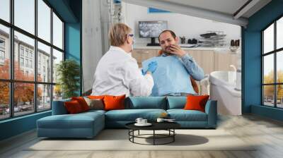 Dentist doctor explaining oral hygiene to patient with toothache discussing healthcare treatment during stomatological consultation in dental office room. Concept of medicine service Wall mural