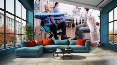 Disabled senior man being assisted by physical therapist by doctor in modern heathcare facility. Elderly invalid patients in hospital following rehabilitation treatment with help from medical personal Wall mural