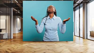 Faithful african american woman with palms faced to sky pleading and begging to have her sins forgiven. Religious and spiritual young person praying for a better and forgiving world. Studio shot Wall mural