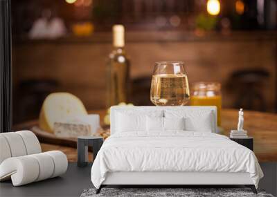 Glass of white wine ,cheese and grapes on old wooden table Wall mural