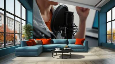 Internet live radio talk show host recording remote podcast while talking to audience at home studio desk. Famous social media influencer sitting in living room while hosting video. Close up shoot Wall mural