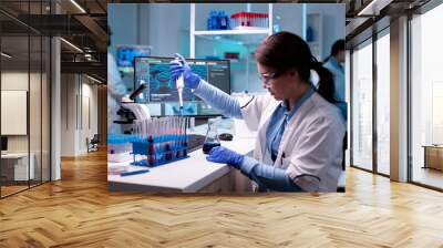 Medical engineer scientist uses micropipette, pipette taking sample from test tube. Woman research a new experiment in modern lab, analyzing pharmaceutical work with modern equipment. Wall mural