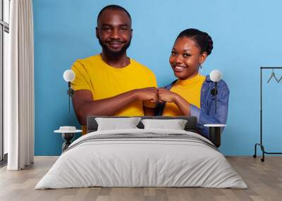 Portrait of smiling couple bumping fists together on camera, celebrating successful teamwork with agreement gesture. Girlfriend and boyfriend being partners and having achievement. Wall mural