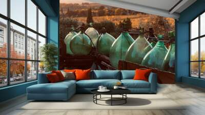 glass demijohn in the wooden cart in chianti in autumn Wall mural