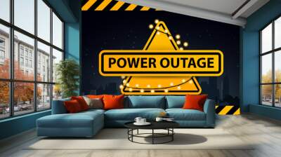 Power outage, yellow warning logo wrapped with a garland on the background of the city without electricity Wall mural