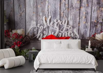 Merry Christmas and Happy Holidays! Christmas tree, Santa hat and the words on old dark wooden rustic background Wall mural