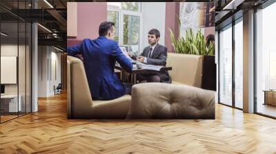 two businessmen communicate happily negotiating in the cafe Wall mural