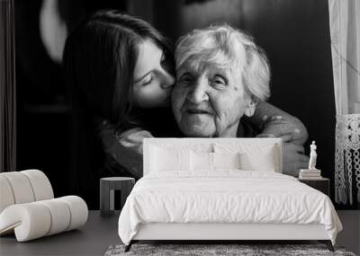 A little girl hugs her grandmother. Black and white photo. Wall mural